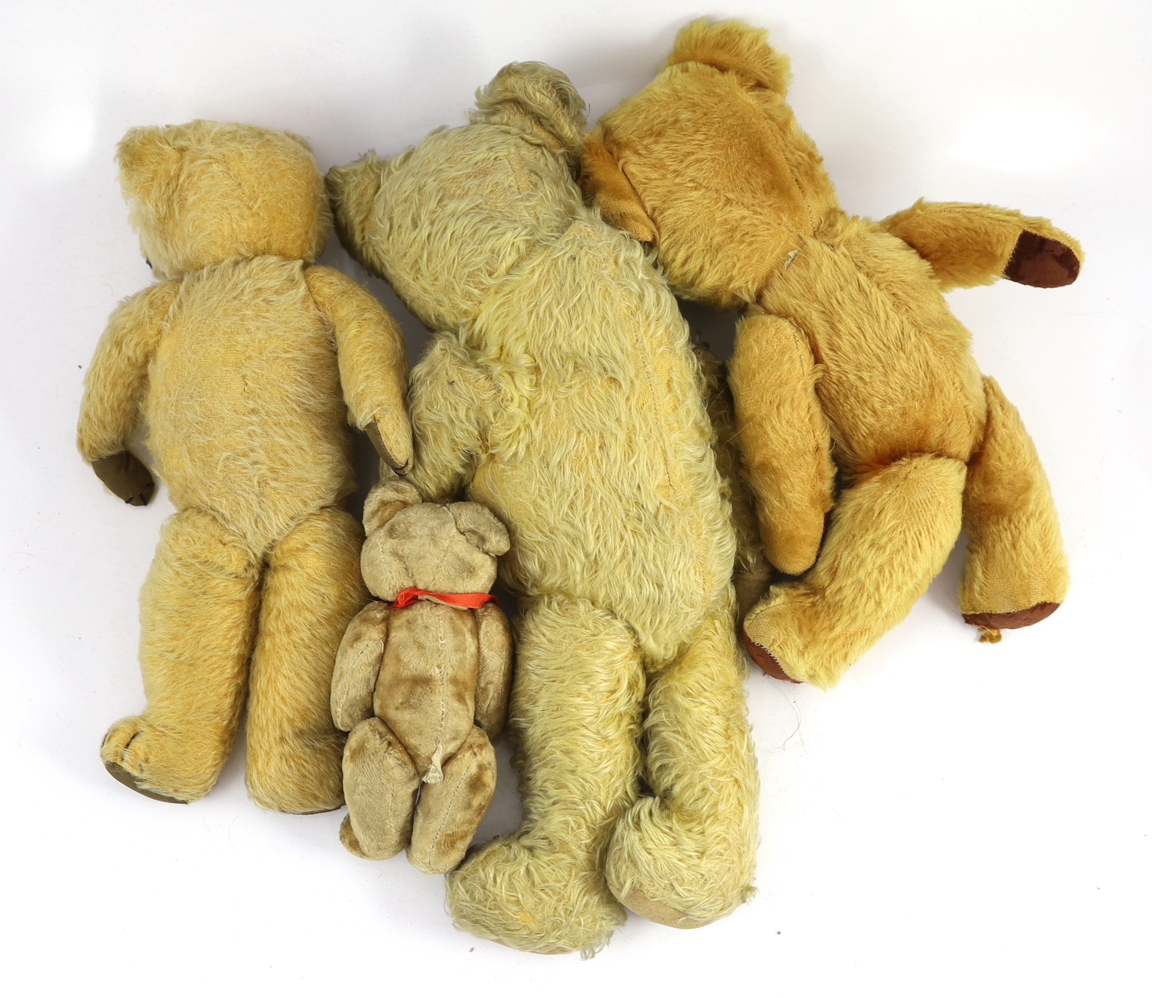 A blonde plush Teddy bear, glass eyes and shaved snout, 18in., and three other Teddy bears